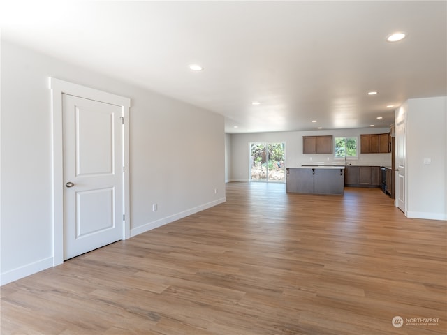 unfurnished living room featuring light hardwood / wood-style flooring and sink