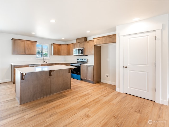 384 Emma Dr, Wenatchee, WA 98801 - kitchen featuring a breakfast bar, a kitchen island, light wood-type flooring, and appliances with stainless steel finishes
