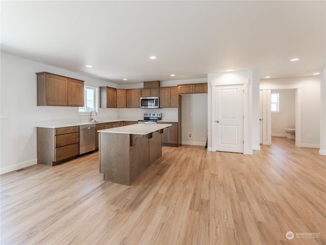 384 Emma Dr, Wenatchee, WA 98801 - kitchen with appliances with stainless steel finishes, light wood-type flooring, a breakfast bar, sink, and a kitchen island