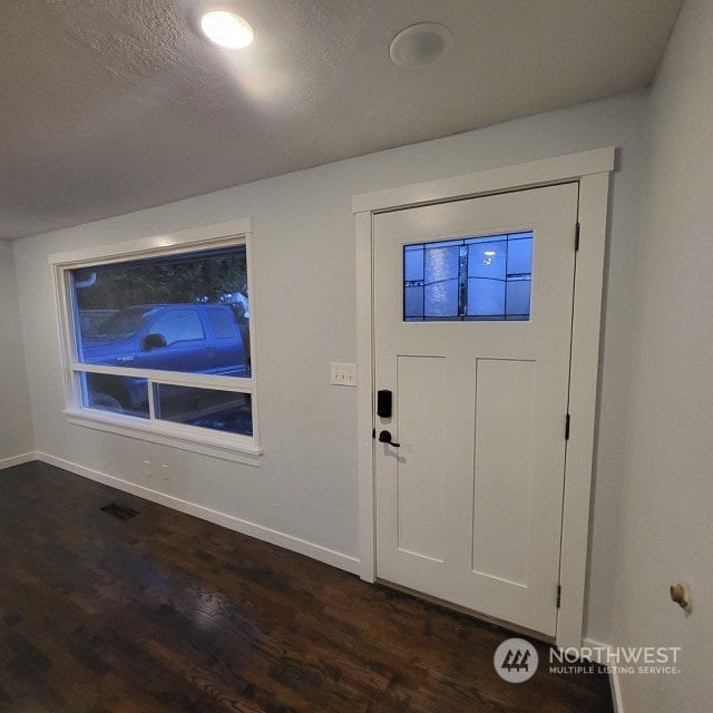 foyer with a textured ceiling and dark wood-type flooring