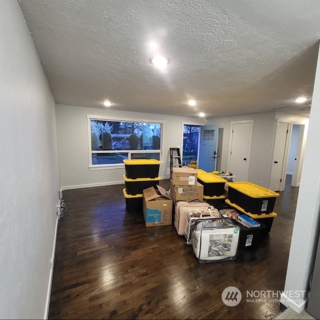 living room featuring a textured ceiling and dark wood-type flooring