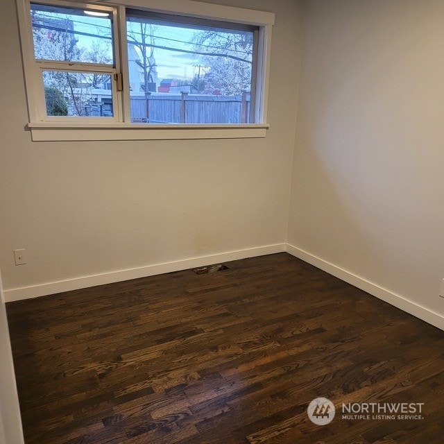 spare room featuring dark hardwood / wood-style flooring