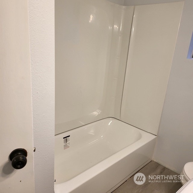 bathroom with toilet and shower / washtub combination