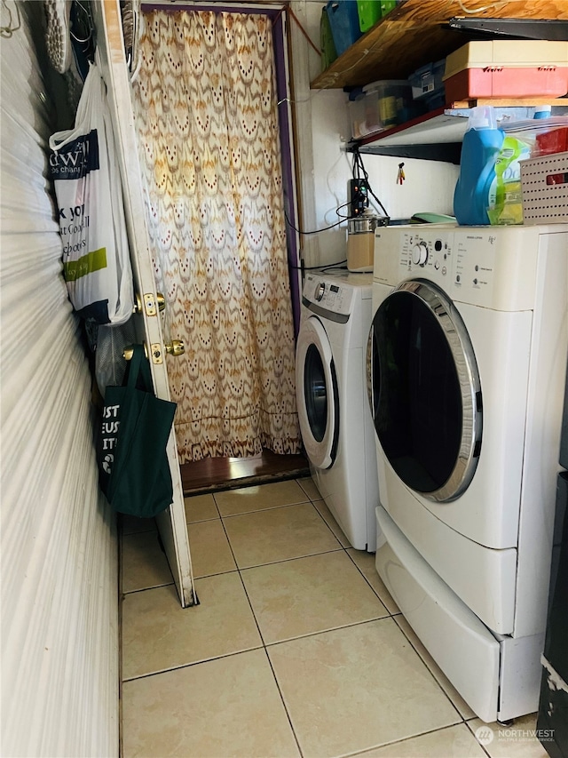 clothes washing area with light tile patterned flooring and independent washer and dryer