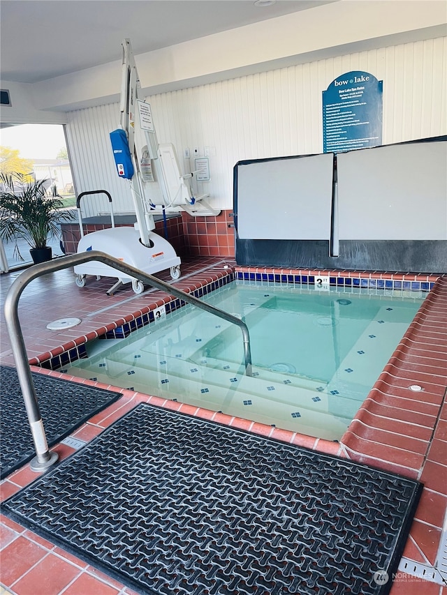 view of swimming pool with an indoor hot tub