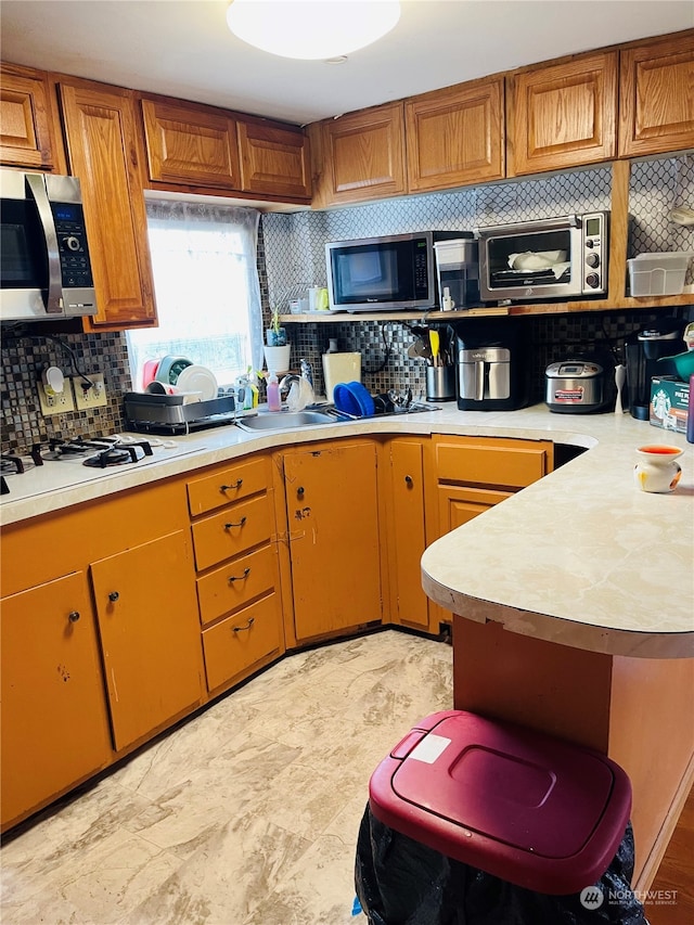 kitchen featuring white gas stovetop and decorative backsplash