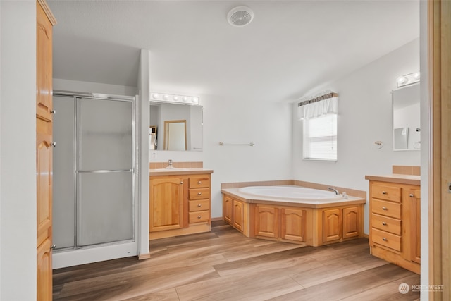 bathroom with vanity, hardwood / wood-style flooring, and shower with separate bathtub