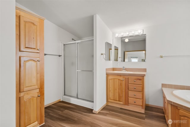 bathroom featuring hardwood / wood-style flooring, a shower with door, and vanity