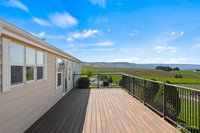 wooden deck with a rural view and a mountain view