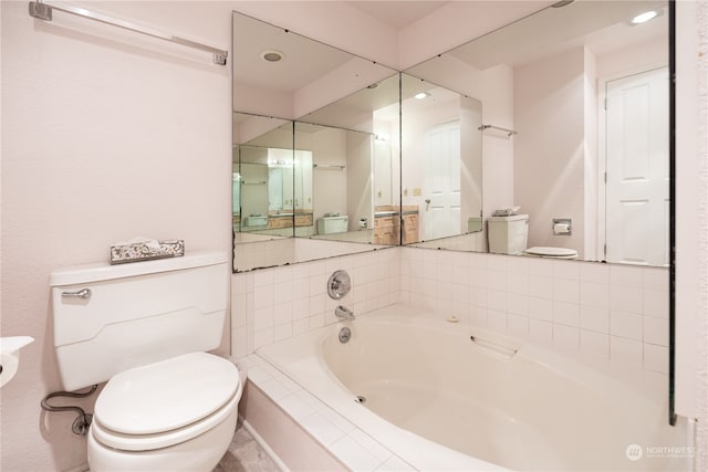 bathroom with tiled tub and toilet