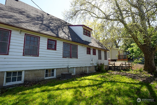 rear view of property featuring central AC unit, a yard, and a wooden deck