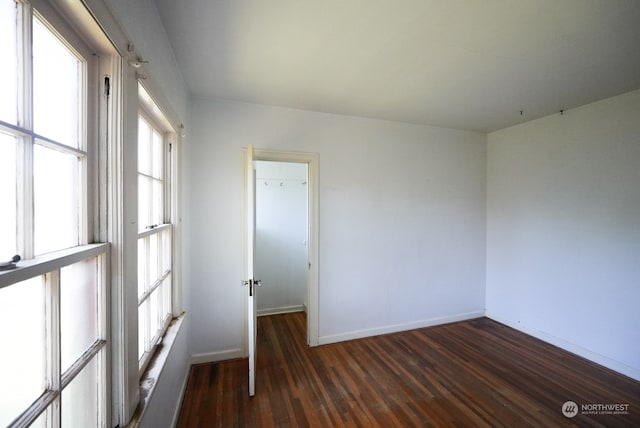 empty room with a healthy amount of sunlight and hardwood / wood-style floors