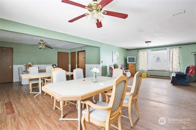 dining space featuring hardwood / wood-style floors, ceiling fan, and baseboard heating