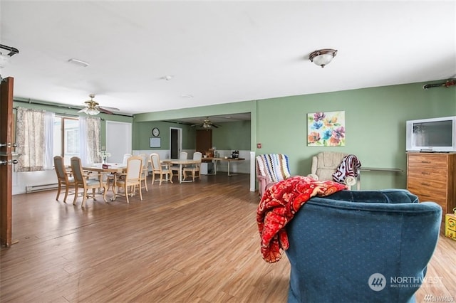 interior space featuring a baseboard heating unit, wood-type flooring, and ceiling fan