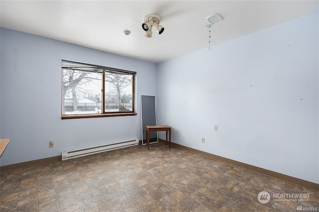 unfurnished room with a baseboard heating unit and dark tile flooring