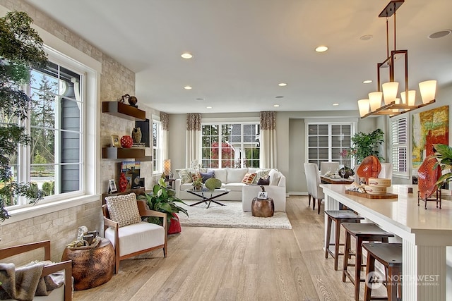 interior space with a stone fireplace, light hardwood / wood-style flooring, and a healthy amount of sunlight