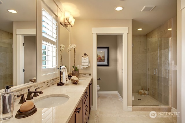 bathroom with tile patterned flooring, vanity, a shower with door, and toilet