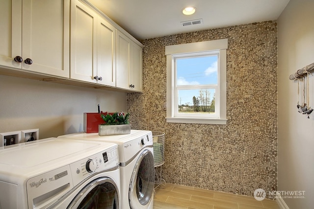 washroom featuring cabinets, independent washer and dryer, and light hardwood / wood-style floors