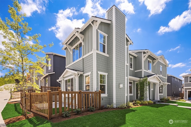 view of front facade featuring a chimney, a front lawn, board and batten siding, and a wooden deck