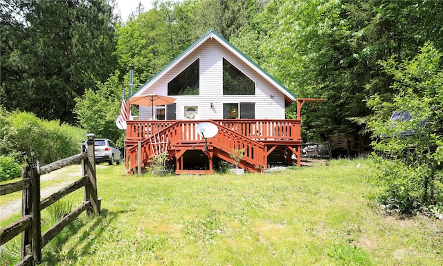 rear view of property with a deck and a lawn