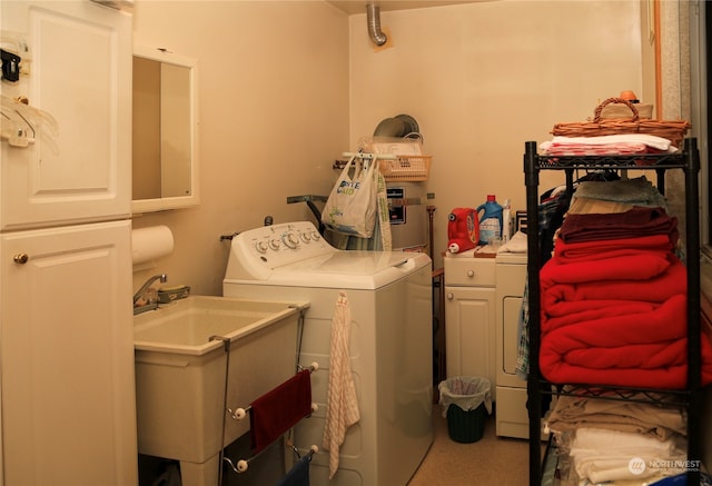 laundry area with separate washer and dryer, sink, and cabinets