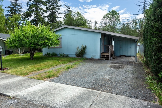 view of front facade with crawl space, an attached carport, gravel driveway, and a front yard