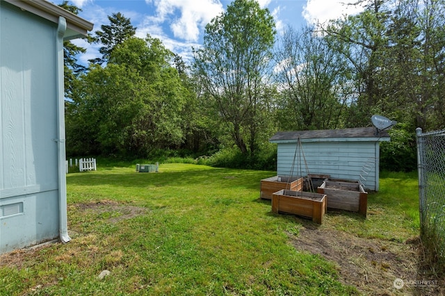 view of yard featuring an outbuilding, a storage unit, and a vegetable garden