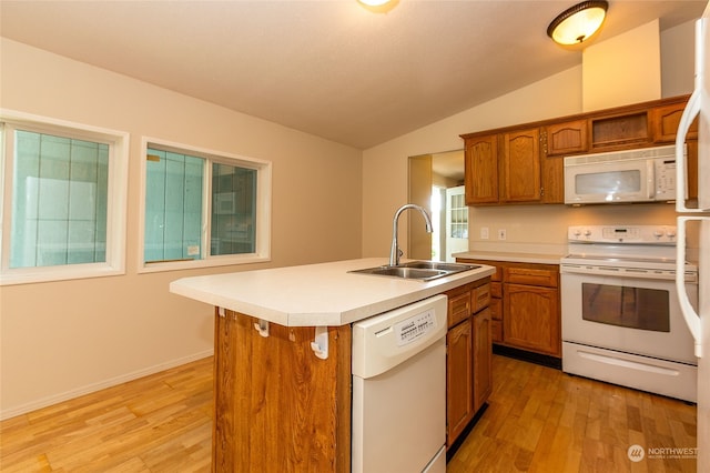 kitchen with brown cabinets, white appliances, lofted ceiling, and a sink