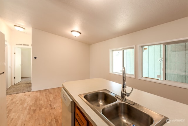 kitchen with visible vents, dishwasher, light wood-type flooring, light countertops, and a sink