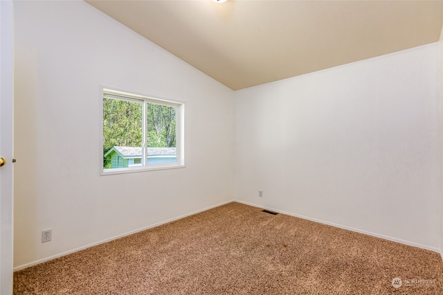 empty room with visible vents, baseboards, lofted ceiling, and carpet