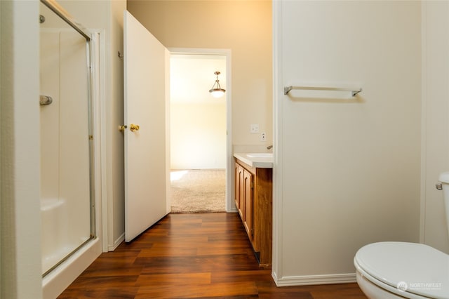 full bath with vanity, toilet, wood finished floors, and a stall shower