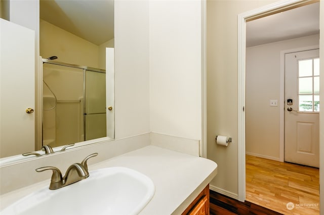 bathroom with an enclosed shower, vanity, baseboards, and wood finished floors