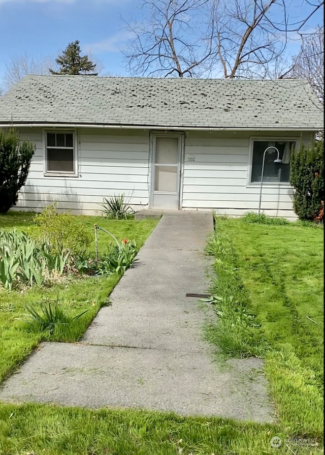 view of exterior entry with a lawn