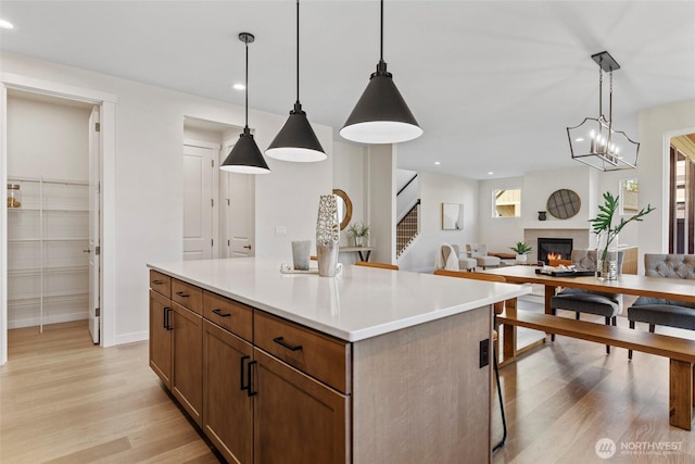 kitchen with light hardwood / wood-style floors, hanging light fixtures, and a center island