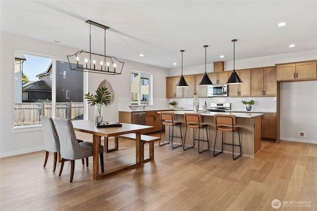 dining space featuring light wood-type flooring and sink