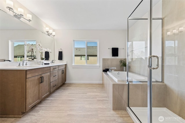 bathroom featuring vanity, shower with separate bathtub, a healthy amount of sunlight, and wood-type flooring