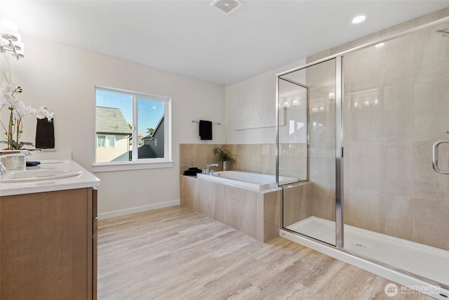 bathroom featuring hardwood / wood-style flooring, independent shower and bath, and vanity