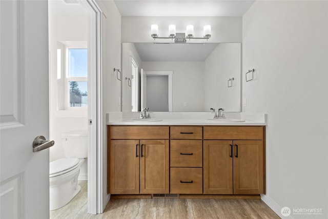 bathroom featuring vanity, toilet, and hardwood / wood-style floors