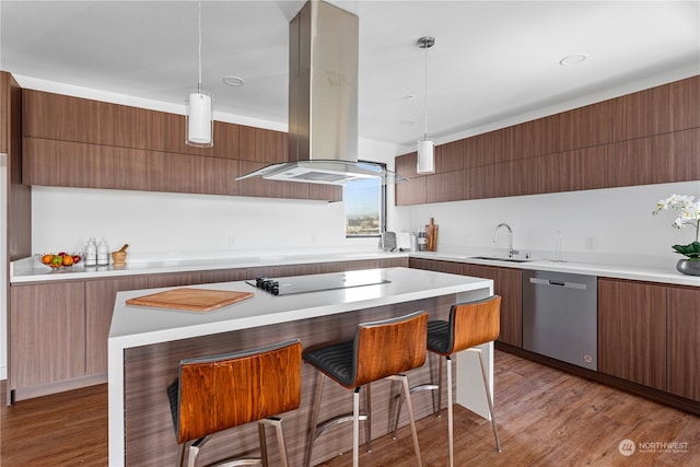 kitchen featuring island exhaust hood, black electric cooktop, stainless steel dishwasher, and decorative light fixtures