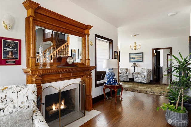 living room featuring an inviting chandelier, a high end fireplace, and hardwood / wood-style floors