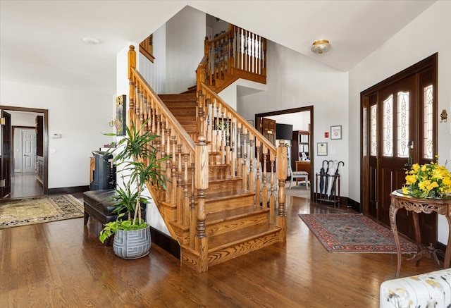 entrance foyer with wood-type flooring and a towering ceiling