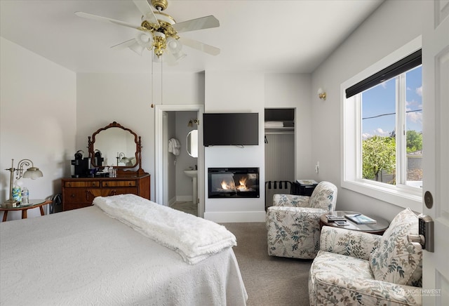 carpeted bedroom with ceiling fan, a closet, and ensuite bathroom