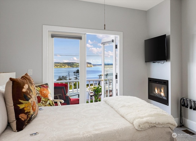 bedroom with a water view and access to exterior