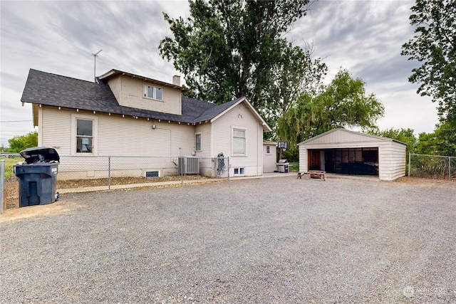 view of property exterior with a garage, an outdoor structure, and central AC unit