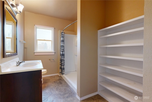 bathroom with vanity, toilet, and walk in shower