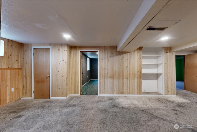 interior space featuring wooden walls and carpet flooring