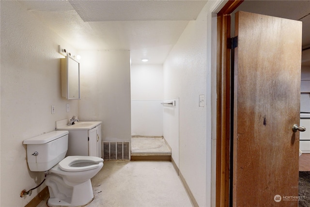 bathroom featuring concrete flooring, vanity, and toilet