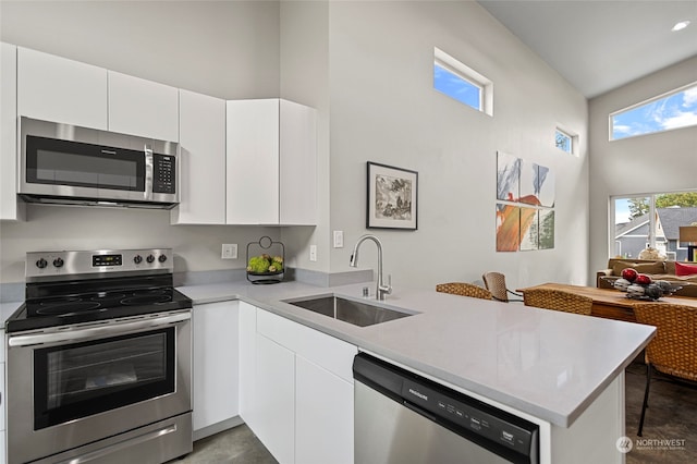 kitchen with white cabinetry, appliances with stainless steel finishes, sink, and kitchen peninsula