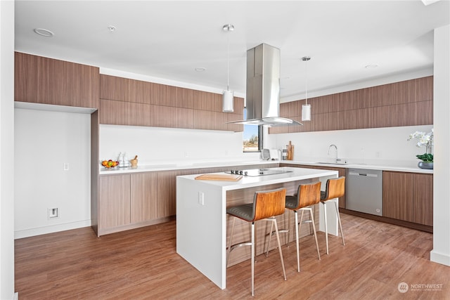 kitchen featuring light hardwood / wood-style flooring, a breakfast bar, hanging light fixtures, dishwasher, and island range hood