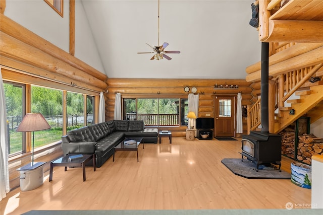 living room featuring high vaulted ceiling, log walls, and light wood-type flooring